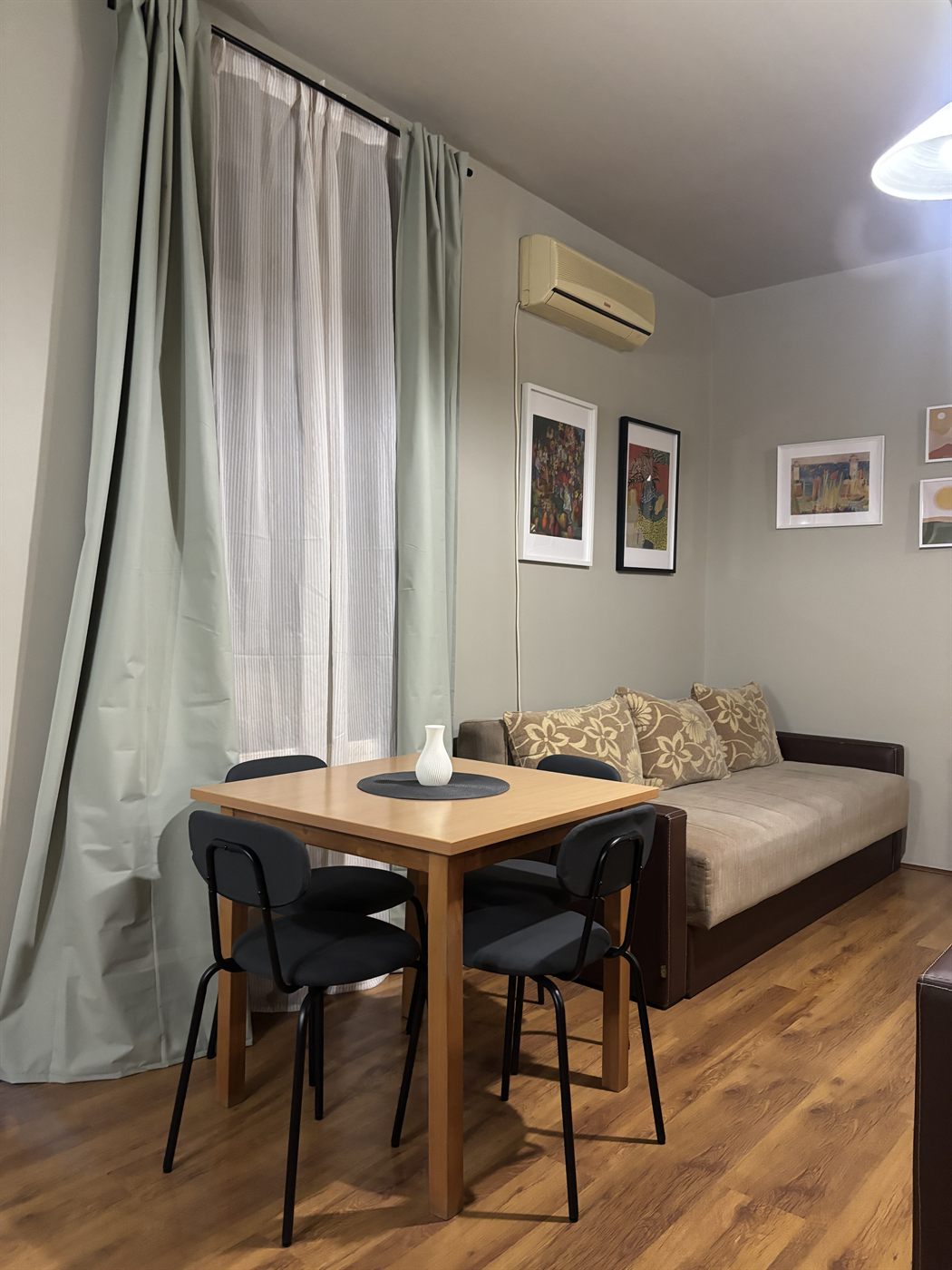Dnevna soba sa trosedom na razvlačenje, trpezarijskim stolom i velikim prozorom